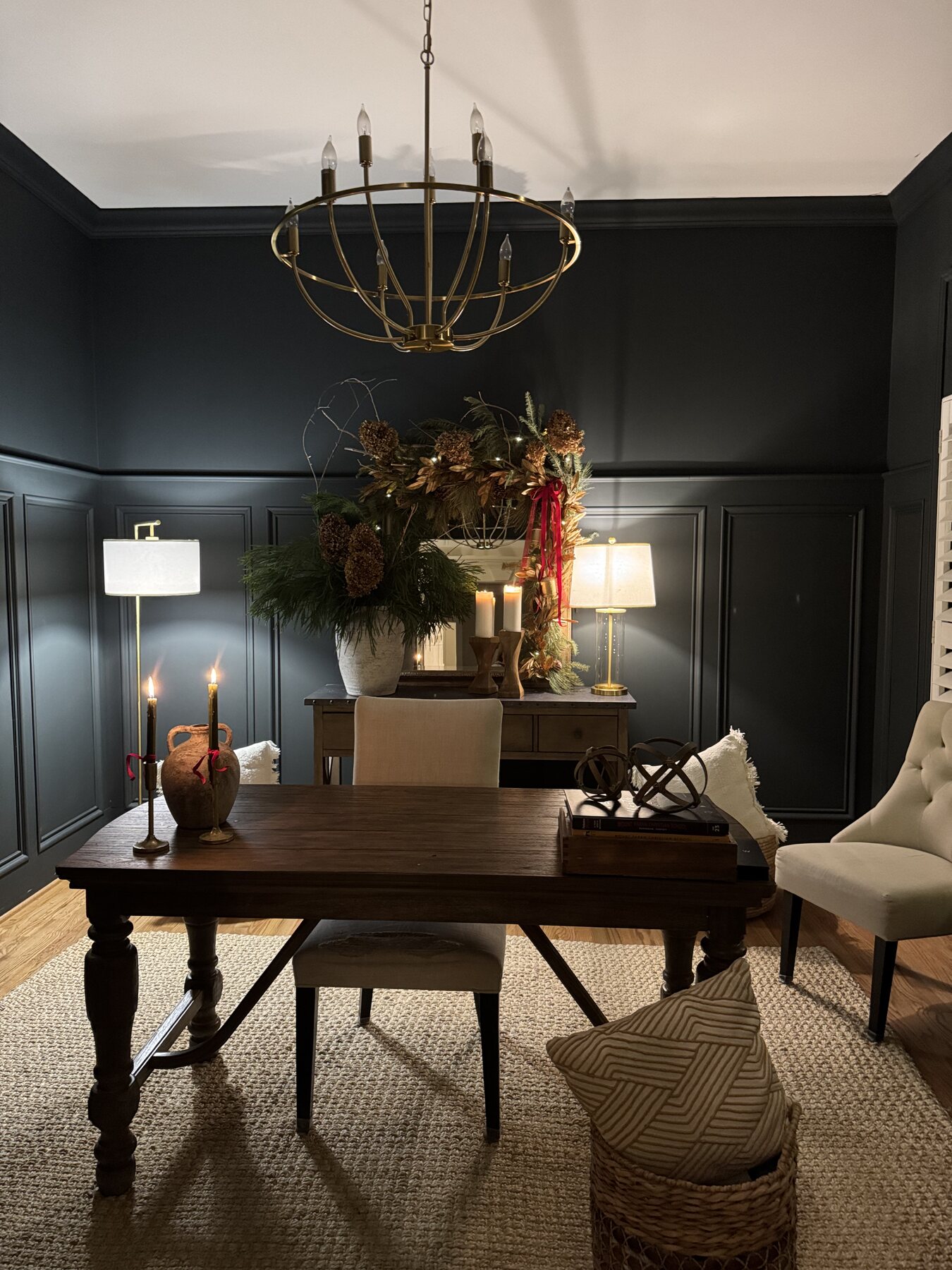 Moody home office with dark paneled walls and a wood writing desk