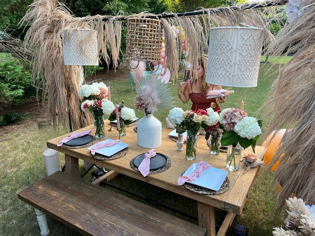 Outdoor gathering table layered with natural textures and soft florals